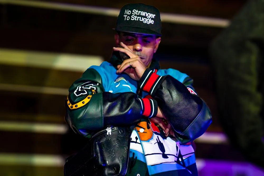 Artist standing between songs under club lighting