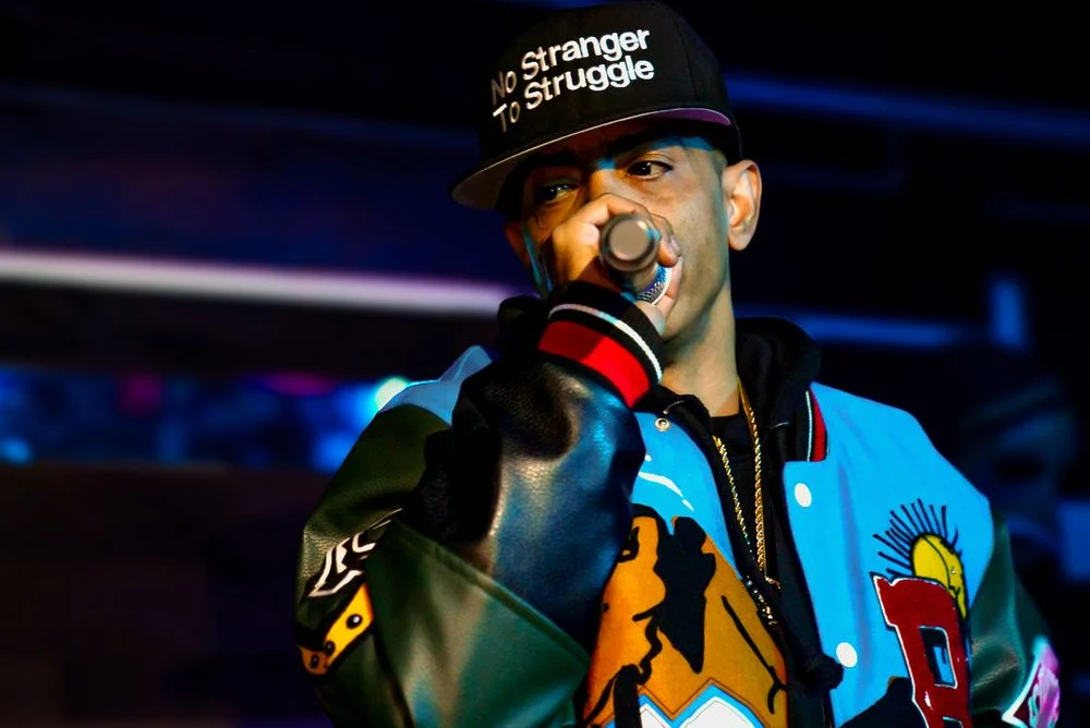 Performer holding a microphone under blue stage lighting