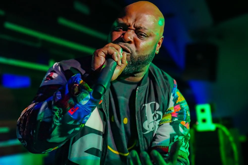 Rapper performing under green and blue club lighting