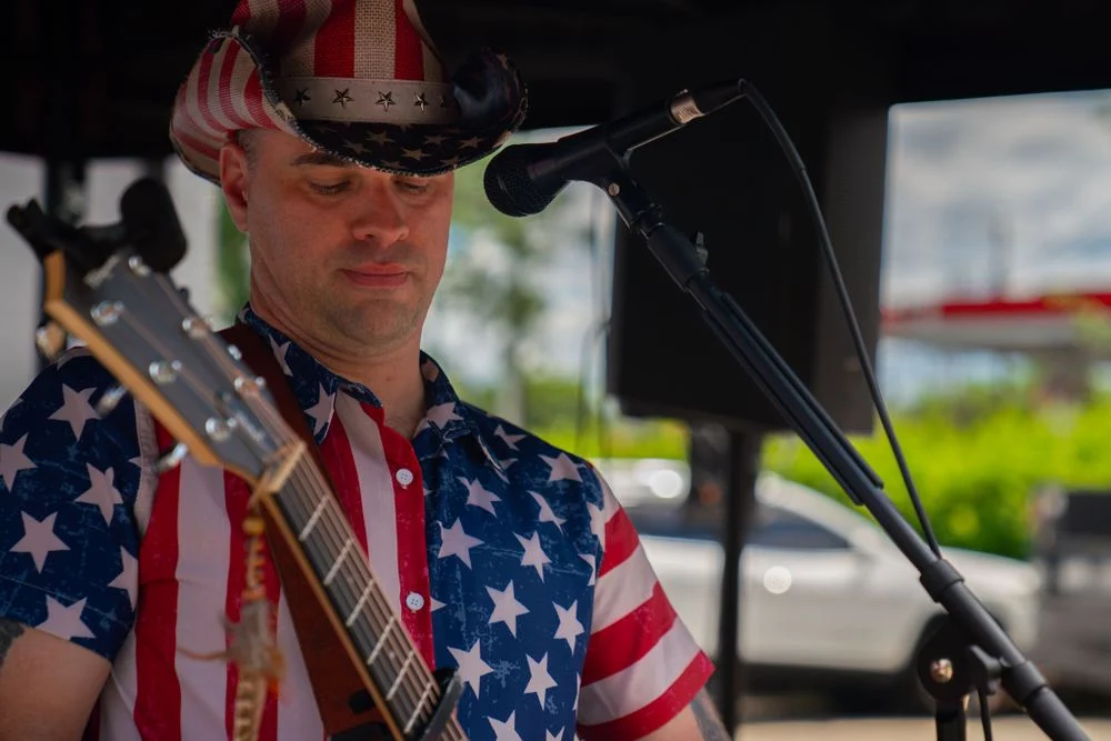 Guitarist performing on an outdoor event stage