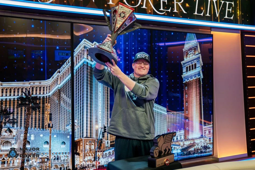 Poker champion raising a trophy on stage