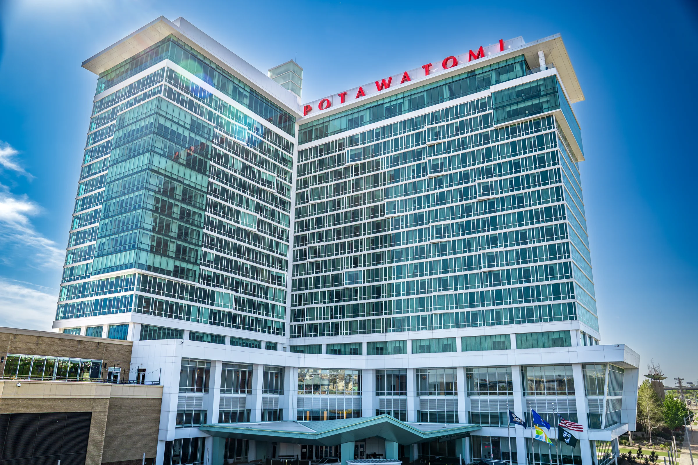 The Potawatomi hotel tower rises against a vivid blue sky in daylight.