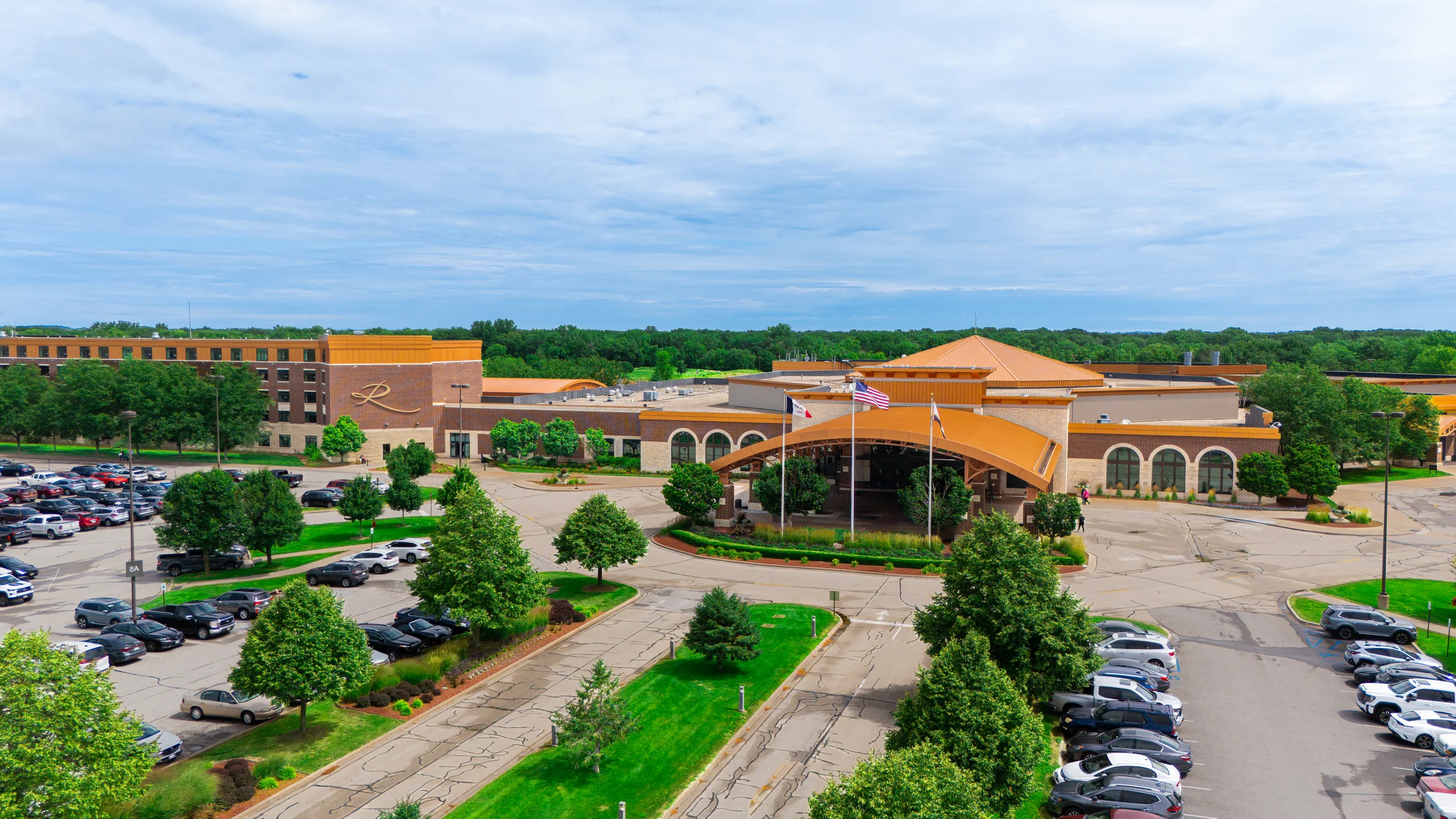 An elevated view shows a sprawling casino resort entrance, parking lots, and surrounding trees.