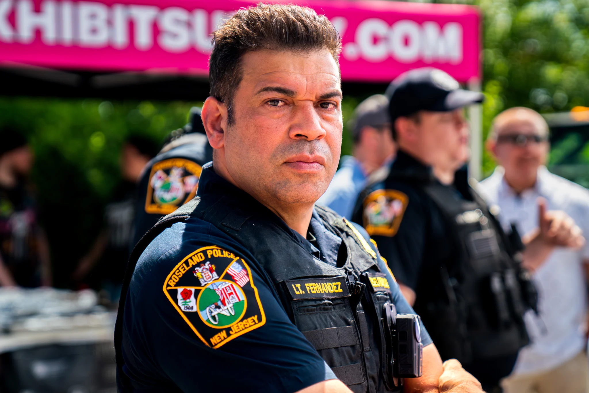 Roseland Police Lt. Fernandez stands in uniform with other officers at an outdoor event.