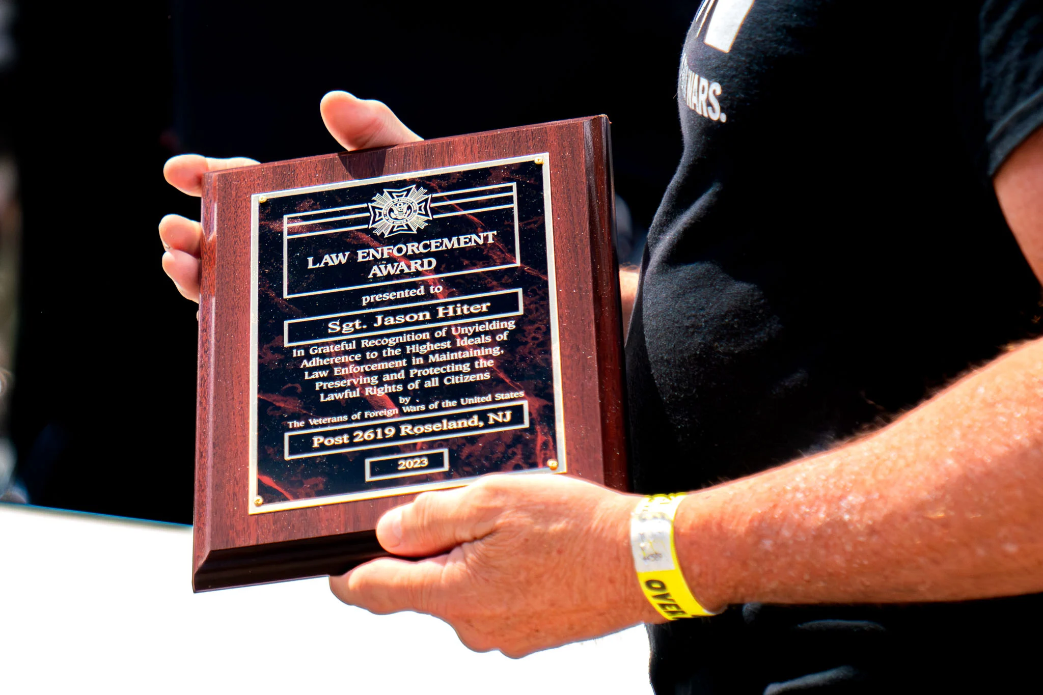Hands hold a 2023 law enforcement award plaque presented to Sgt. Jason Hiter.