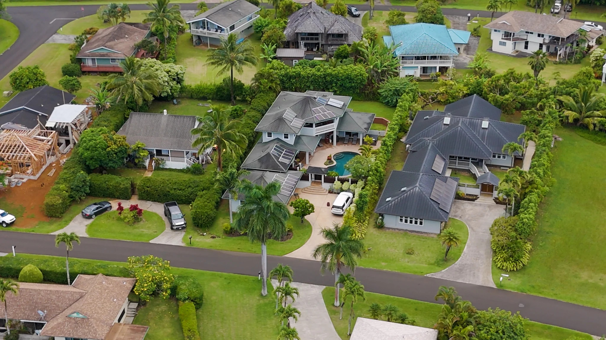 Aerial view of tropical homes and landscaped streets in a quiet residential neighborhood.