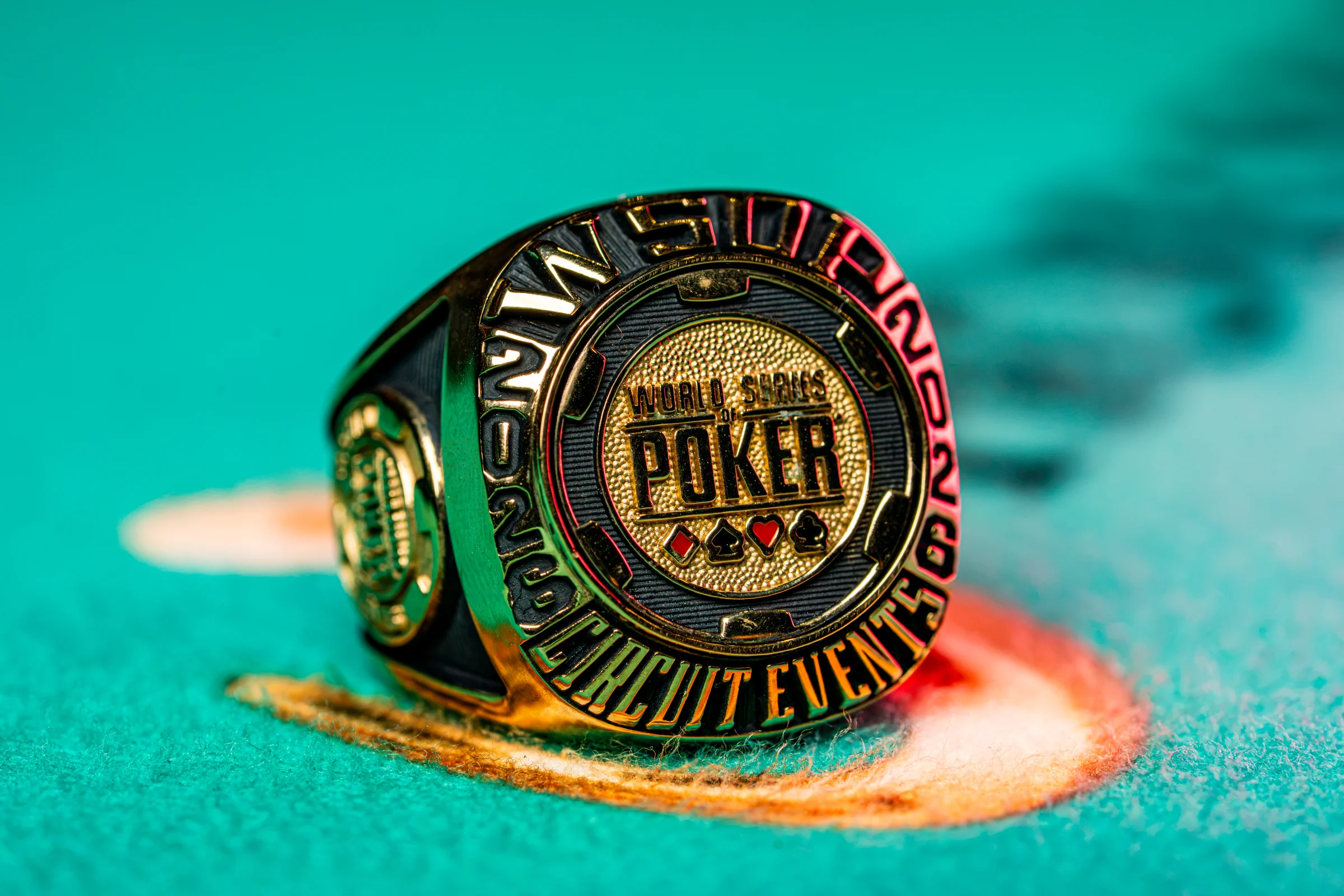 A gold World Series of Poker Circuit Event ring rests on green felt.